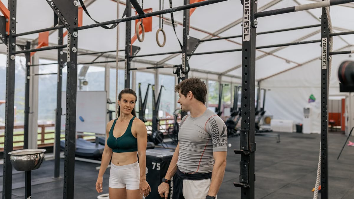 Man and woman exercising at an indoor gym, focused on fitness goals.