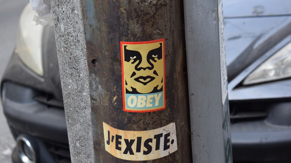A car parked next to a pole with a sticker on it